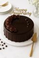 Dark chocolate anniversary cake with glossy mirror glaze, golden topper, and fresh delivery in Ahmedabad