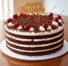 Black Forest cake in round shape with happy birthday topper- Ahmedabad Delivery